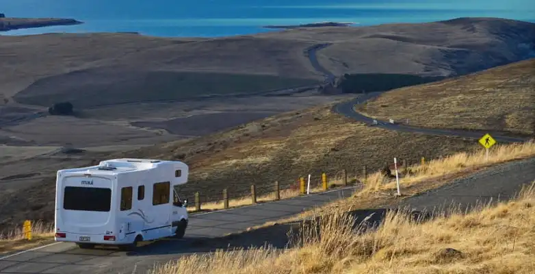 Weißes Wohnmobil auf einer Straße am Tekapo-See am Mount John in Neuseeland